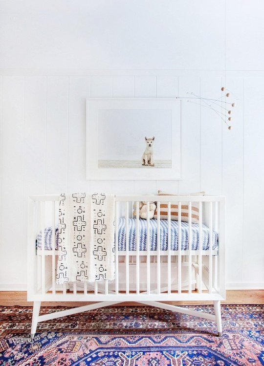white nursery with a white wrought-iron crib
