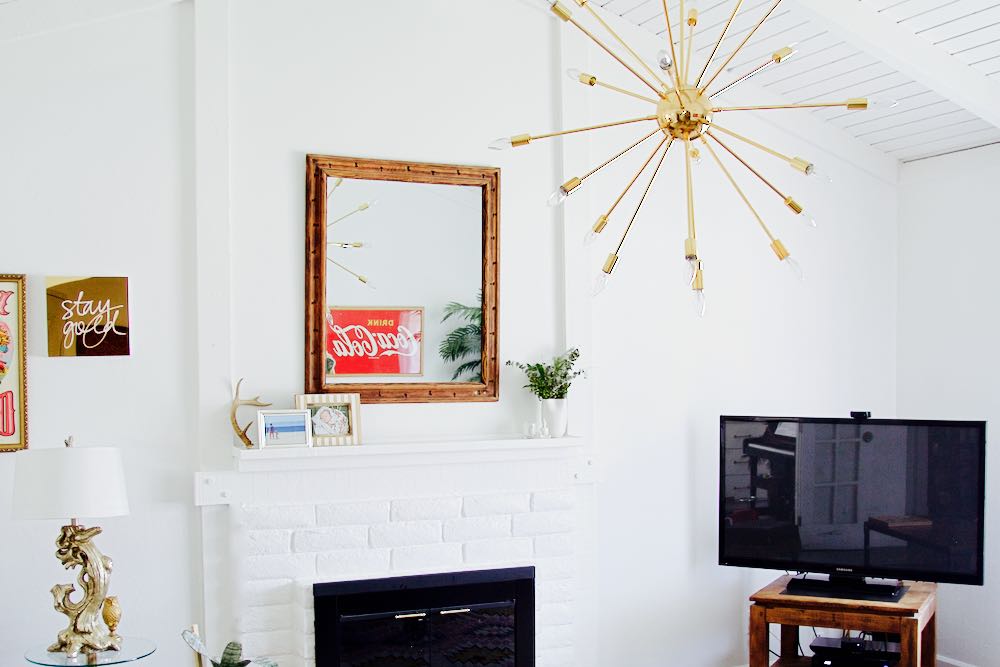 White, bright painted living room with gold chandelier