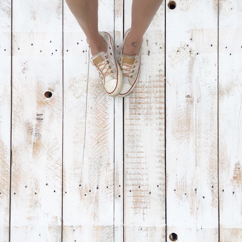 Distressed white Converse sneakers with leather laces